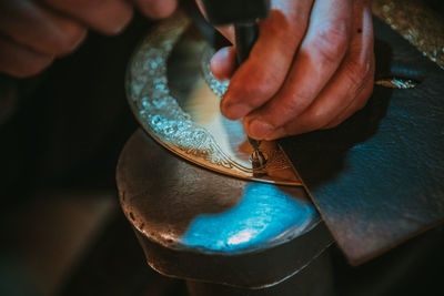 Close-up of hand carving metal