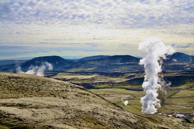 Emission of geothermal energy from icelandic landscape against sky