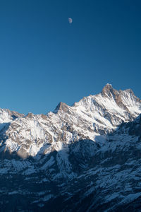 Scenic view of snow covered mountains against clear sky