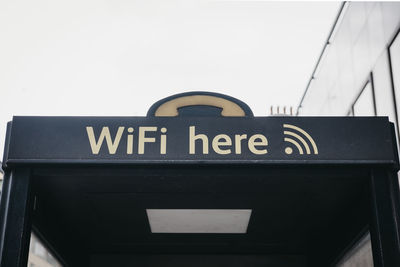 Low angle view of information sign against sky