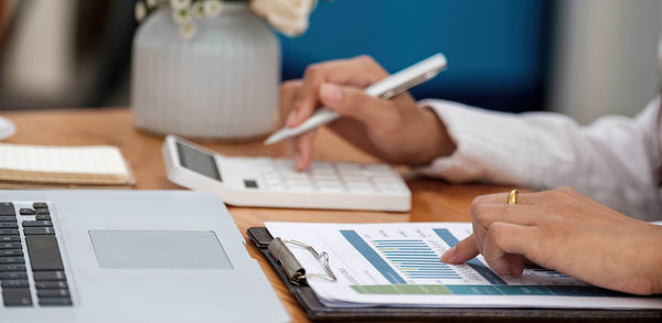 Midsection of man using mobile phone on table