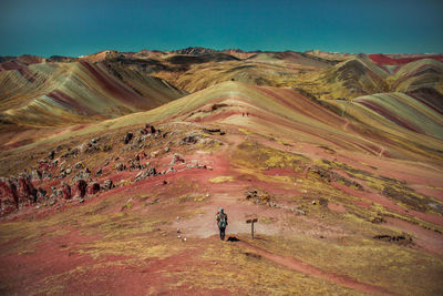 Rear view of woman standing on landscape against sky