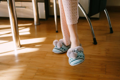 Low section of woman standing on hardwood floor