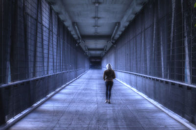 Rear view of woman running on tunnel