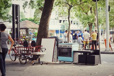 People standing by abandoned objects at street in city