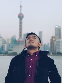 Man looking away against buildings in city