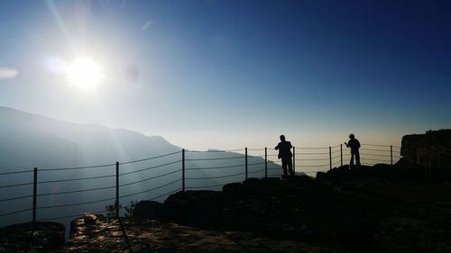 Silhouette people on mountain against clear sky during sunset