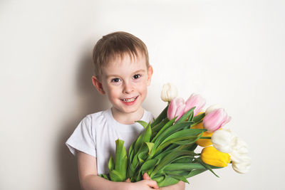 Portrait of cute girl with flowers against white background