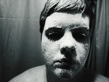 Close-up of man with power face paint against curtain