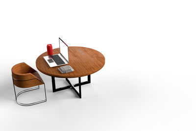 Close-up of empty chair on table against white background