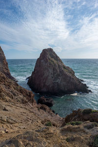 Scenic view of rocks in sea against sky