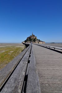 Surface level of railway tracks against clear blue sky