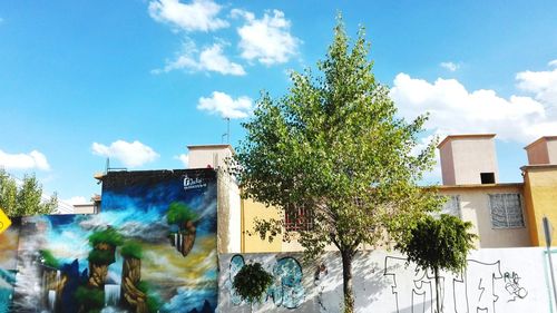 Trees and plants against blue sky in city