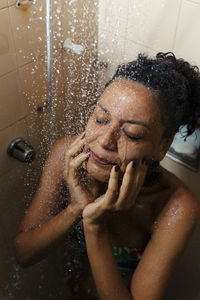 Portrait of a woman in the bathroom washing herself. 