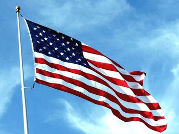 Low angle view of american flag against sky