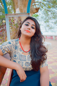 Portrait of young woman sitting outdoors