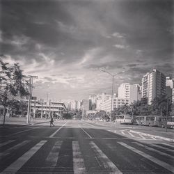 View of city street against cloudy sky