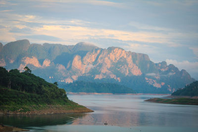 Scenic view of sea and mountains against sky