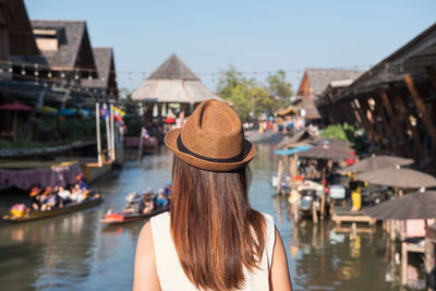 Rear view of woman with umbrella in canal