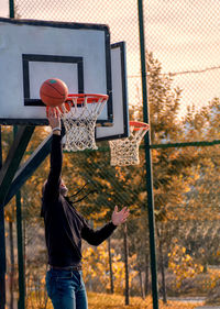 Man playing with basketball hoop