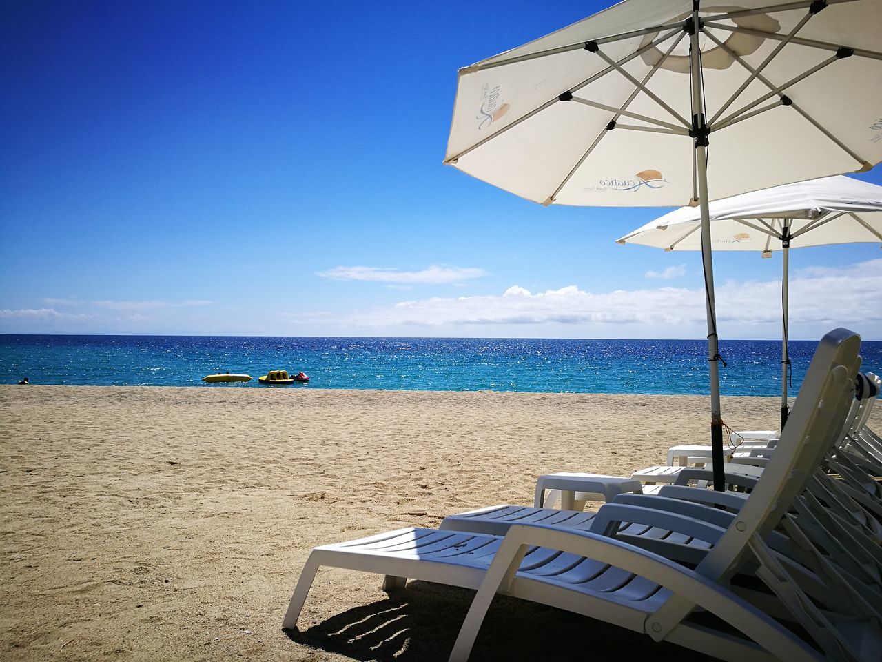 sea, horizon over water, beach, blue, water, sky, boat, nautical vessel, mode of transport, tranquil scene, vacations, scenics, ocean, tranquility, in a row, shore, day, coastline, outdoors, summer, tourism