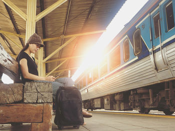 Full length of man sitting at train against sky
