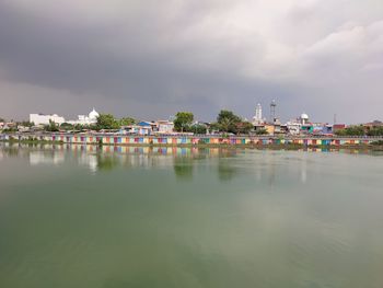 Scenic view of lake against sky in city