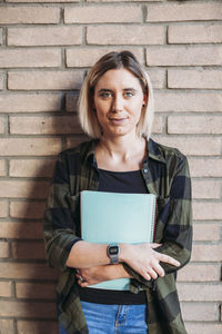 Portrait of woman student on brick wall