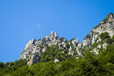 Low angle view of rocks against blue sky