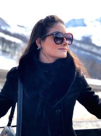 Woman wearing sunglasses standing in snow