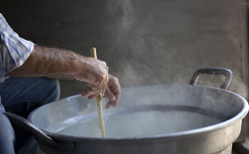 Close-up of male hand making ricotta