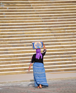 Full length of young woman standing by railing