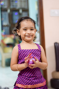 Portrait of girl smiling while standing at home