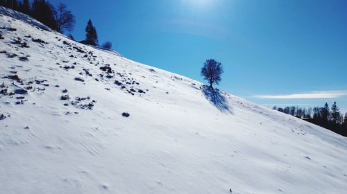 Scenic view of snow covered mountain against blue sky