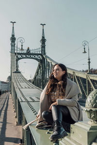 Lifestyle photo of attractive woman sitting on liberty bridge in budapest, hungary