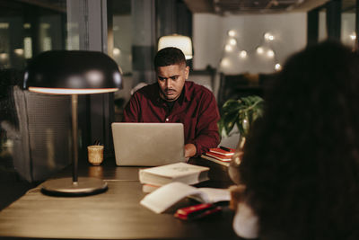 People working on table in illuminated room