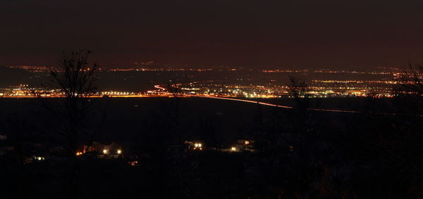 Illuminated city against sky at night