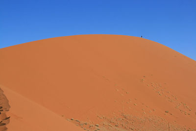 Scenic view of desert against clear blue sky