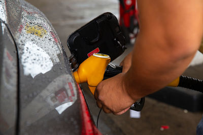 Man filling gasoline fuel in car holding pump. closeup on male hand refuel car. 