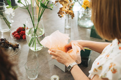 High angle view of woman holding fruit on table