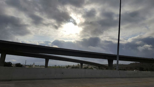 Suspension bridge against cloudy sky