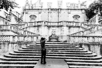 Rear view of woman walking on staircase in city