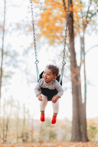 Full length of boy on swing at playground