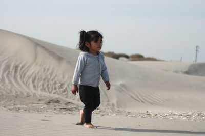 Full length of girl walking on sand