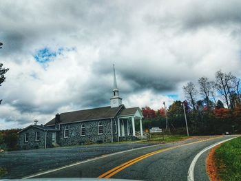 Road by building against sky