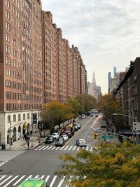 View of city street and buildings against sky