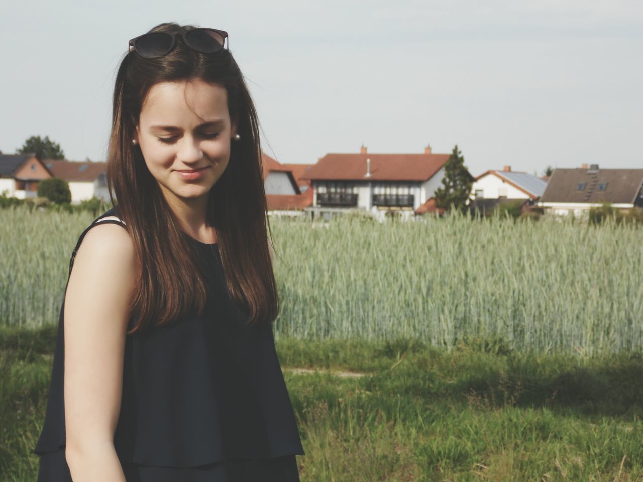 person, field, grass, young adult, portrait, casual clothing, looking at camera, standing, lifestyles, smiling, leisure activity, young women, three quarter length, front view, rural scene, waist up, long hair, clear sky