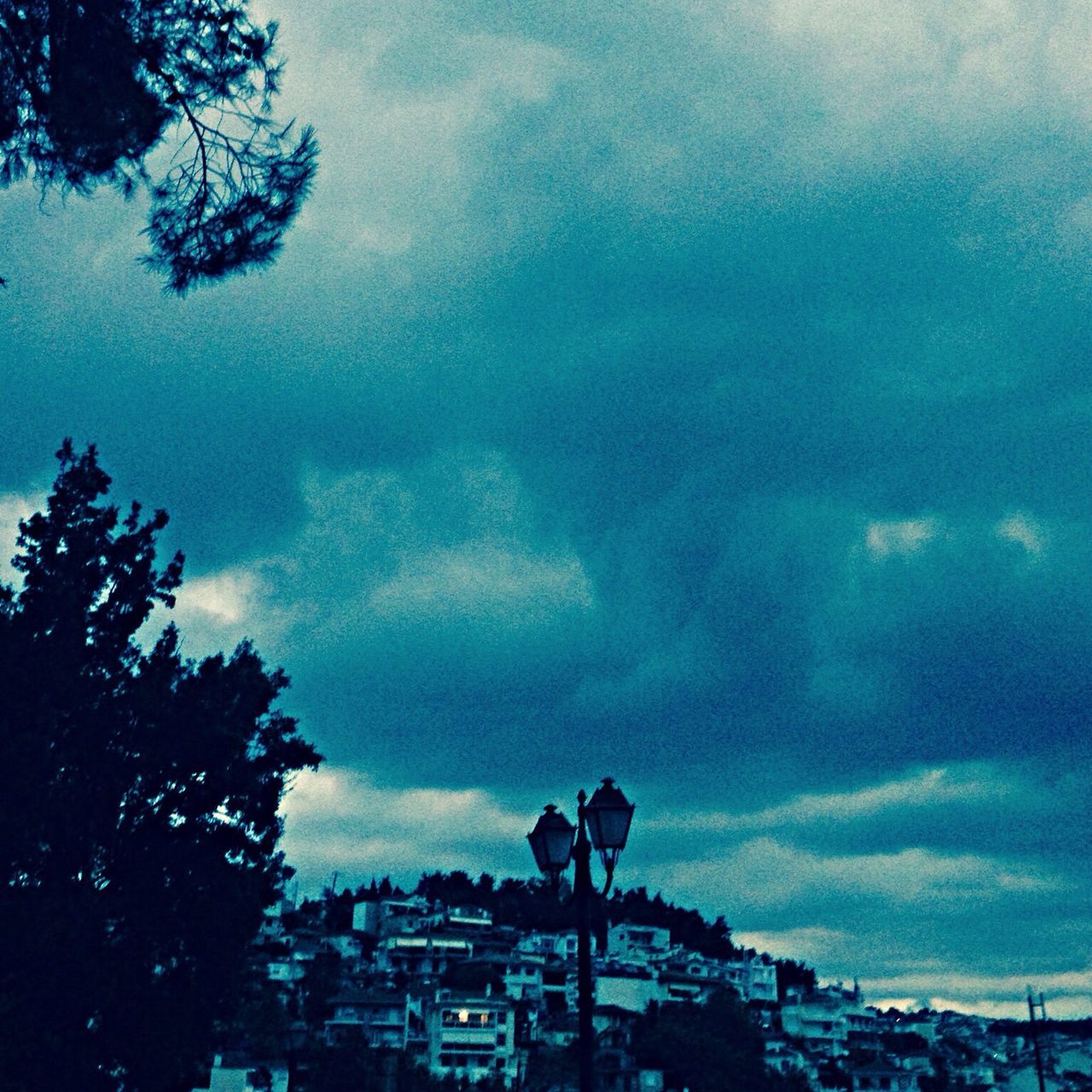 sky, building exterior, cloud - sky, built structure, architecture, cloudy, weather, tree, city, residential building, cloud, overcast, storm cloud, residential structure, dusk, house, low angle view, silhouette, nature, cityscape