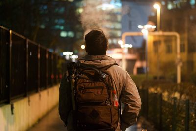 Rear view of man standing at night