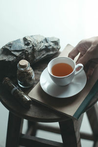 Midsection of person holding tea cup on table